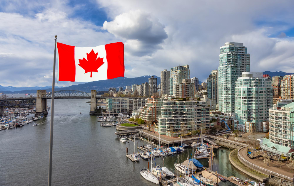 Canadian flag with maple leaf waving against sky