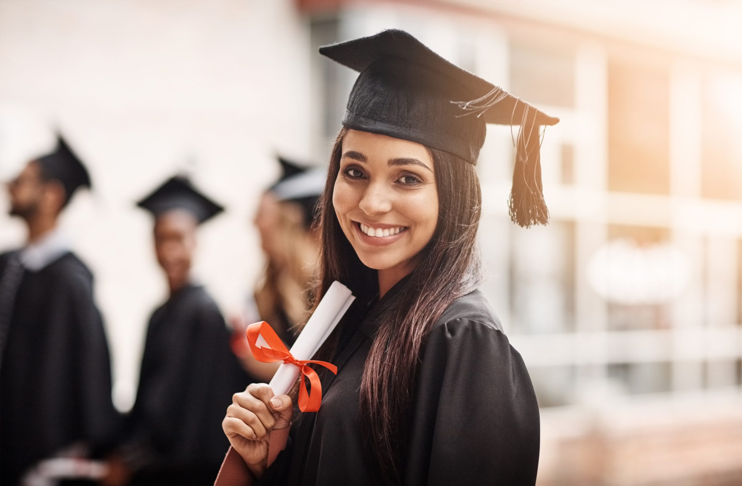 Two graduates in caps and gowns celebrating at commencement ceremony